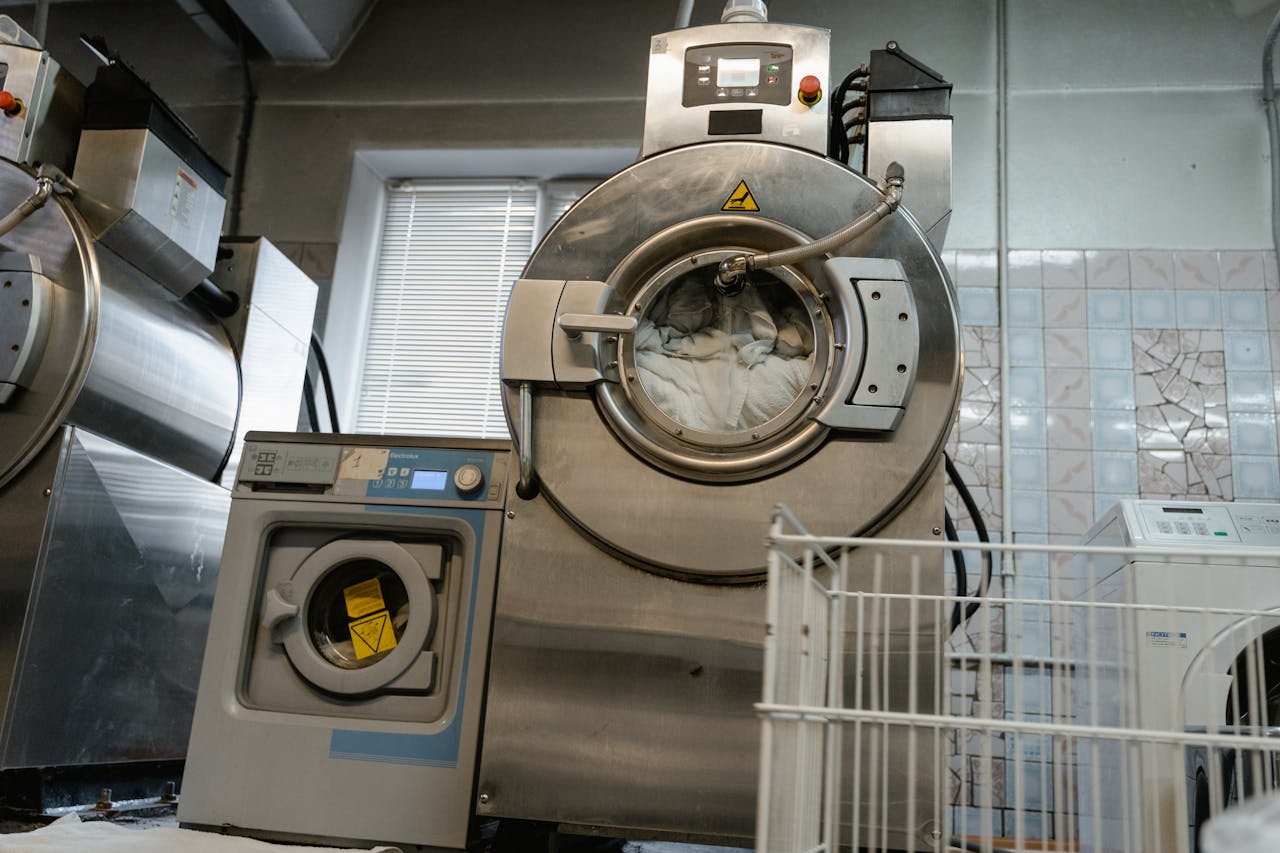 services-02 Large industrial laundry machines in a service room environment.